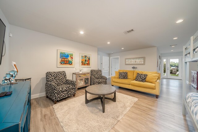 living room featuring visible vents, baseboards, french doors, light wood-type flooring, and recessed lighting