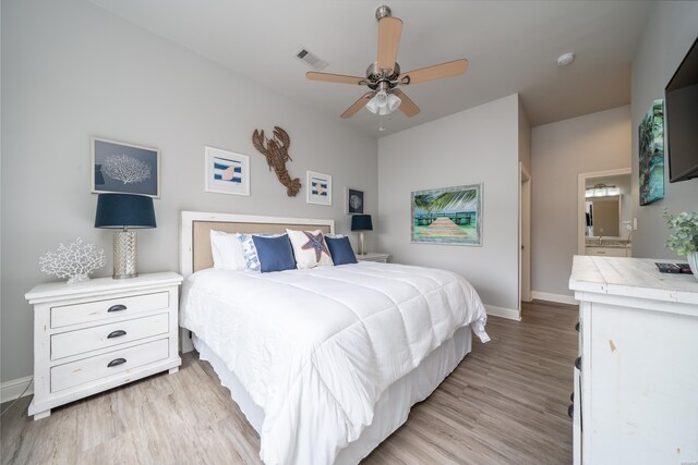 bedroom featuring visible vents, baseboards, a ceiling fan, connected bathroom, and light wood-style floors