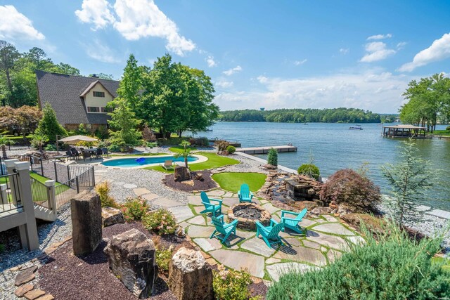 exterior space with a water view, an outdoor fire pit, a dock, and an outdoor pool