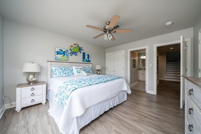 bedroom with a closet, ceiling fan, baseboards, and wood finished floors