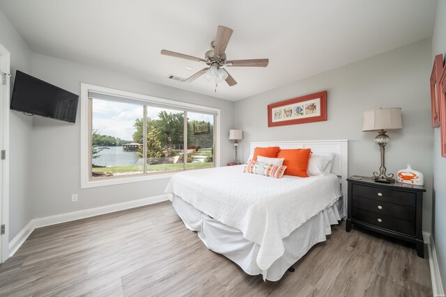 bedroom featuring visible vents, wood finished floors, a ceiling fan, and baseboards