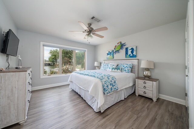 bedroom with baseboards, visible vents, dark wood finished floors, and a ceiling fan