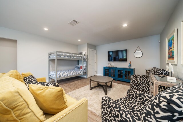 living room with recessed lighting, visible vents, and wood finished floors