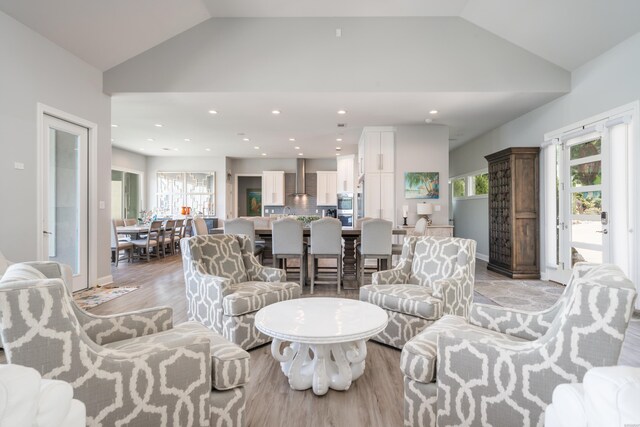 living area with lofted ceiling, light wood finished floors, baseboards, and recessed lighting