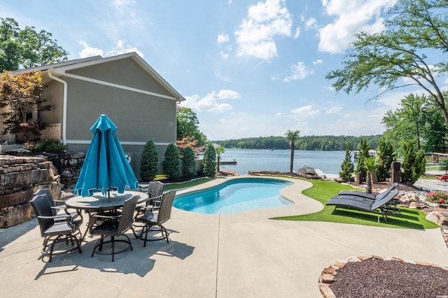 outdoor pool featuring a water view and a patio