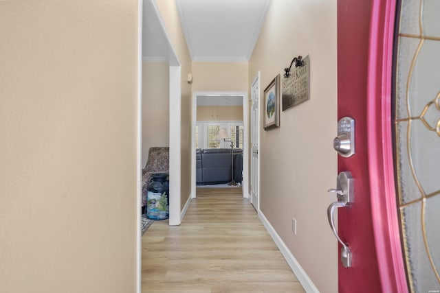 hall with baseboards, wood finished floors, and ornamental molding