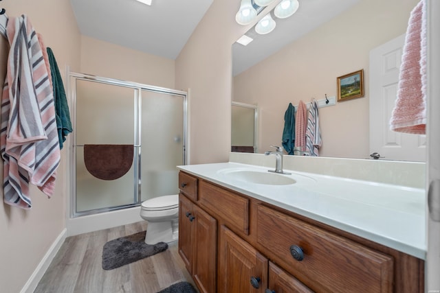 full bath with toilet, a stall shower, wood finished floors, and vanity