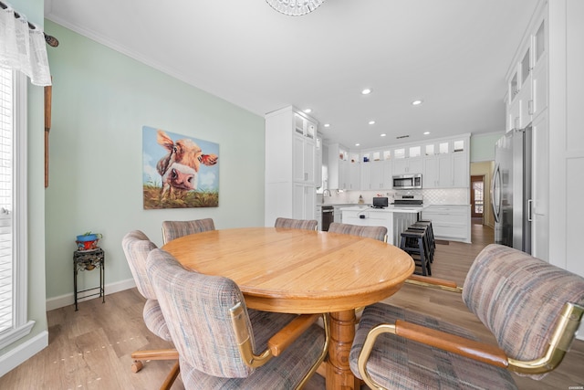 dining area featuring light wood-style flooring, baseboards, crown molding, and recessed lighting