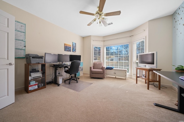 carpeted home office featuring a ceiling fan, visible vents, and baseboards