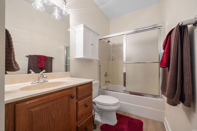 full bath featuring wood finished floors, vanity, toilet, and bath / shower combo with glass door