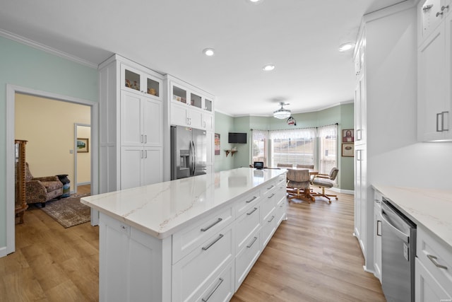 kitchen featuring stainless steel appliances, light wood finished floors, white cabinetry, and crown molding