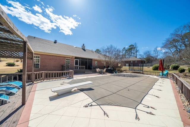 view of swimming pool featuring a patio, a trampoline, and fence