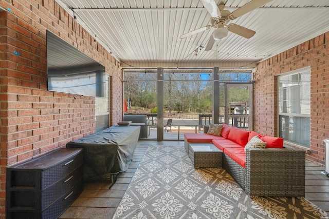 sunroom / solarium featuring a ceiling fan