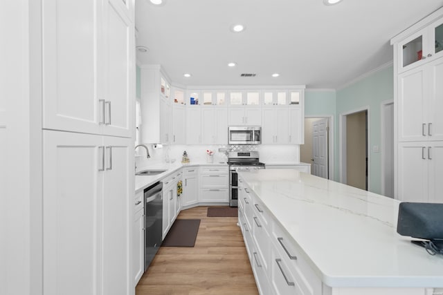 kitchen featuring visible vents, decorative backsplash, appliances with stainless steel finishes, light wood-style floors, and a sink