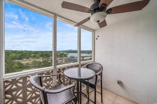sunroom / solarium featuring a ceiling fan