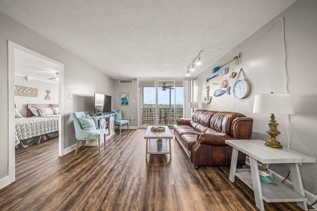 living area with visible vents, baseboards, track lighting, wood finished floors, and a ceiling fan