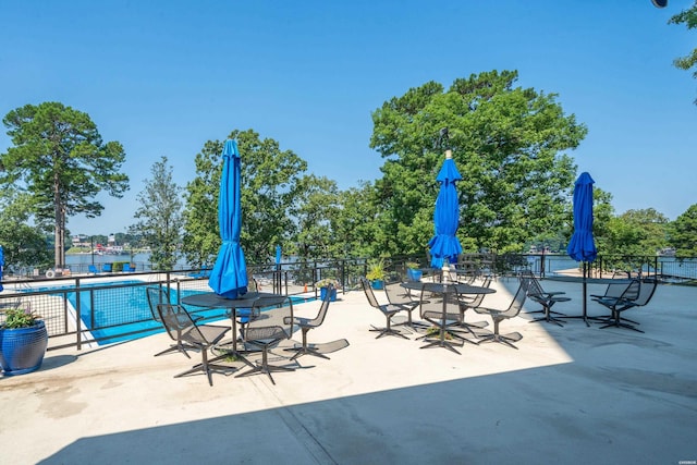 view of patio with fence and a community pool