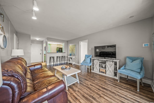 living area with baseboards and wood finished floors