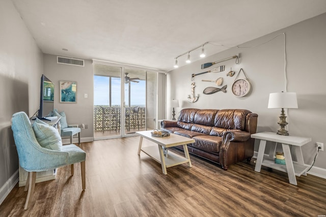 living room featuring visible vents, floor to ceiling windows, wood finished floors, and baseboards