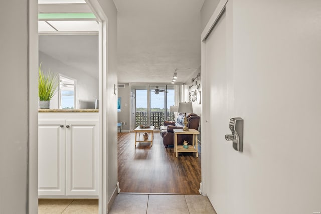 hall with track lighting and light tile patterned floors