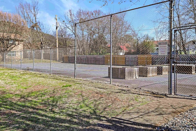 view of tennis court with community basketball court, a gate, and fence