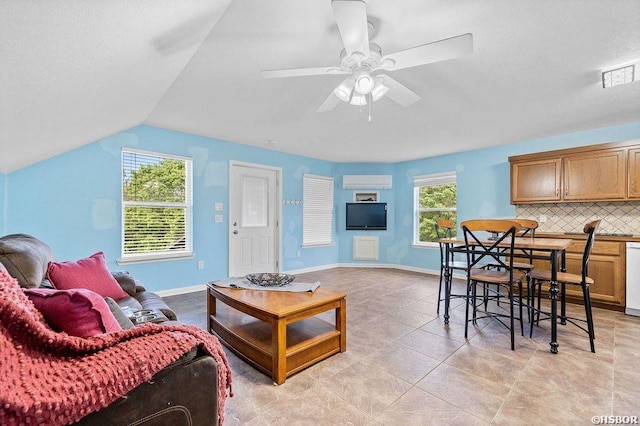 living room with an AC wall unit, a wealth of natural light, visible vents, and baseboards