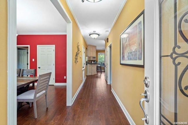 hallway with dark wood-style floors, baseboards, and ornamental molding