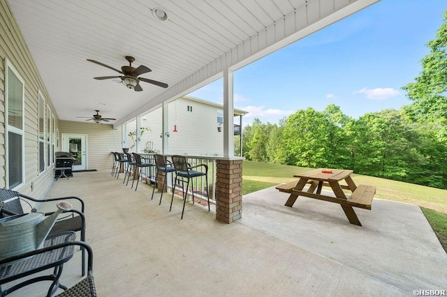 view of patio / terrace featuring outdoor dining area, ceiling fan, outdoor dry bar, and grilling area