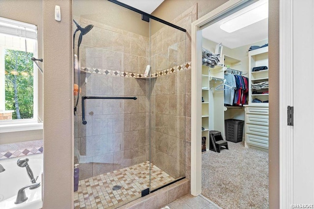 bathroom with a walk in closet and a shower stall