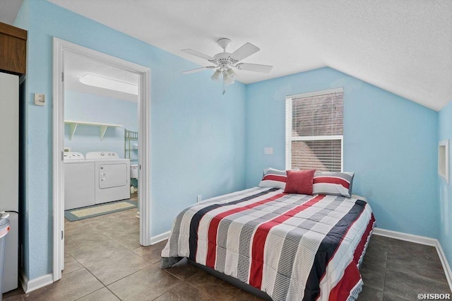 tiled bedroom with ceiling fan, washing machine and dryer, baseboards, and vaulted ceiling