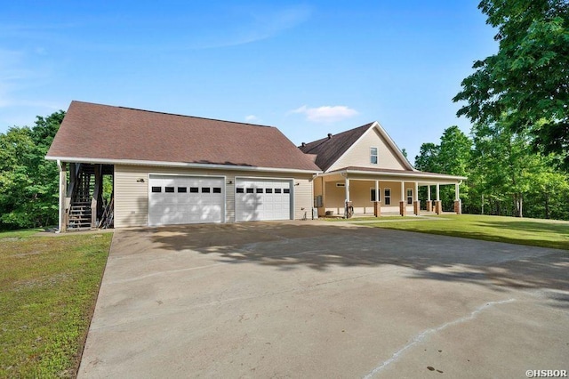 farmhouse inspired home with covered porch, stairway, a front yard, a garage, and driveway