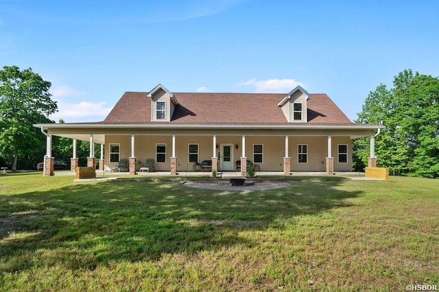 rear view of property with covered porch and a yard