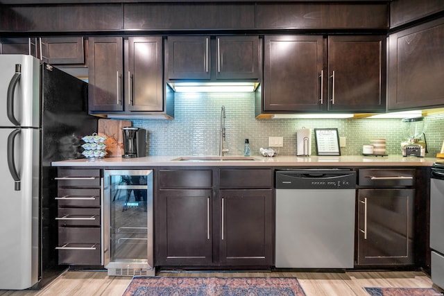 kitchen featuring wine cooler, a sink, light countertops, dark brown cabinets, and dishwasher