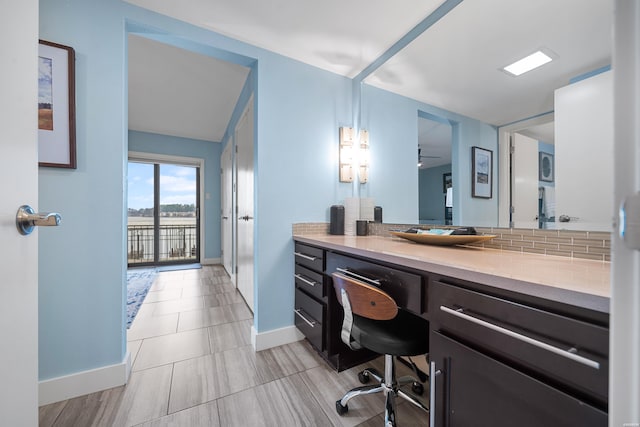 bathroom featuring backsplash, baseboards, and vanity