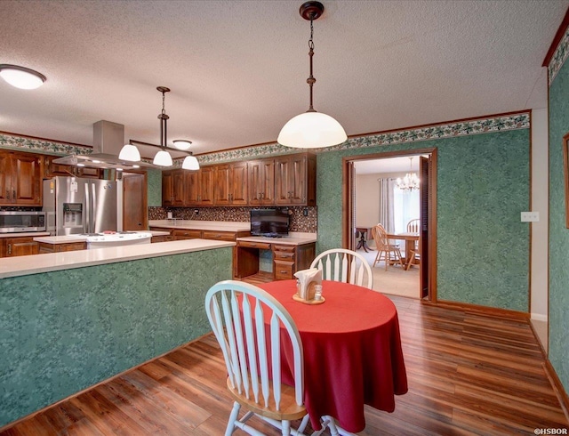7 Sonora Way, Hot Springs Village, AR 71909 - kitchen with appliances with stainless steel finishes, a chandelier, a textured ceiling, wood finished floors, and light countertops