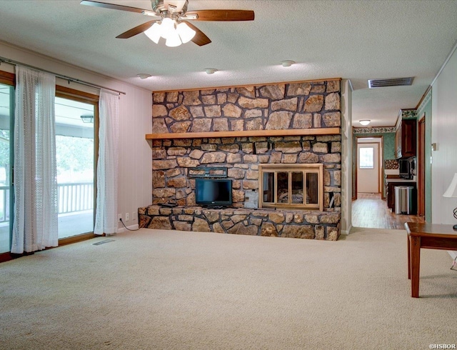 7 Sonora Way, Hot Springs Village, AR 71909 - unfurnished living room with carpet, ceiling fan, a textured ceiling, and a stone fireplace