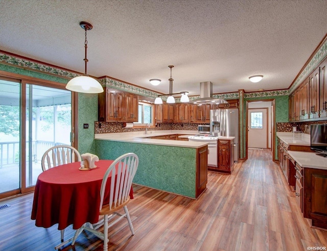 7 Sonora Way, Hot Springs Village, AR 71909 - kitchen with a textured ceiling, a peninsula, light wood-style floors, backsplash, and wallpapered walls