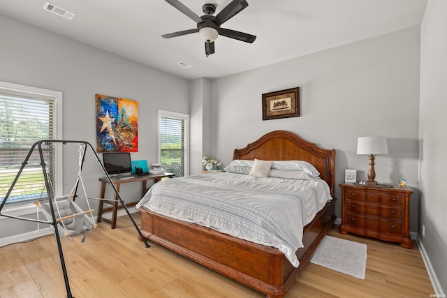 bedroom with light wood-type flooring, visible vents, and baseboards