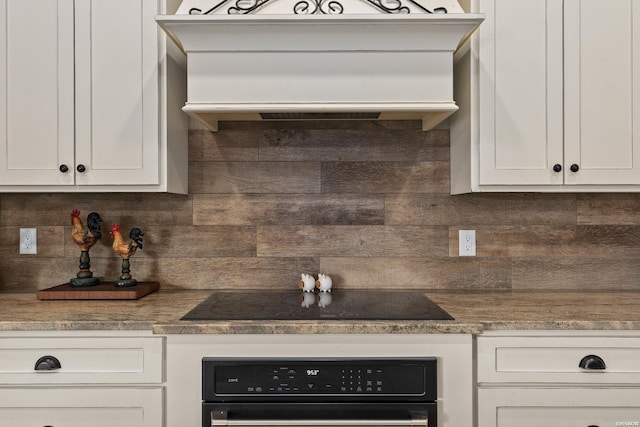 kitchen featuring black appliances, white cabinets, and backsplash