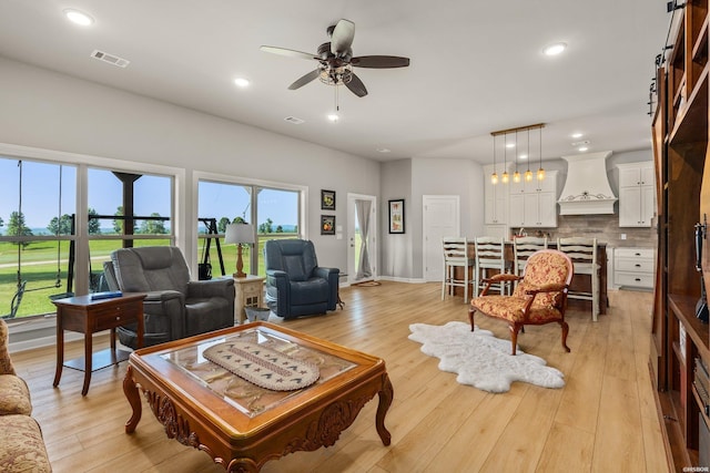 living area with light wood finished floors, visible vents, recessed lighting, and ceiling fan