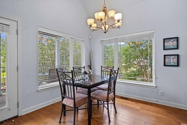 dining area with a wealth of natural light, baseboards, visible vents, and wood finished floors