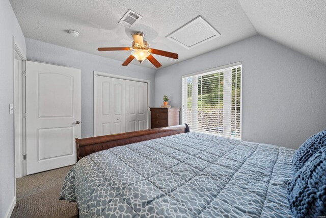 carpeted bedroom with lofted ceiling, ceiling fan, a textured ceiling, visible vents, and attic access