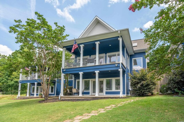 back of property with a balcony and a lawn