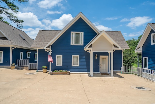 view of front of property featuring a shingled roof and fence