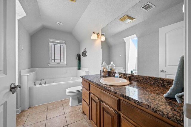 full bath with a textured ceiling, lofted ceiling, a garden tub, vanity, and visible vents