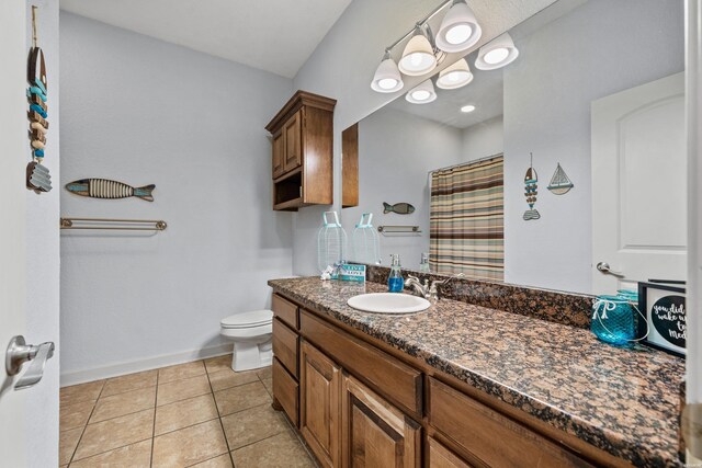 full bathroom featuring curtained shower, toilet, vanity, baseboards, and tile patterned floors