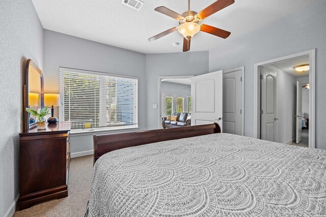 bedroom with visible vents, ceiling fan, light carpet, and baseboards