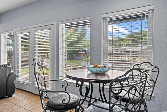 dining space featuring plenty of natural light, light tile patterned flooring, and a textured wall