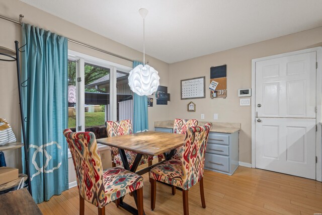dining space featuring light wood-style flooring and baseboards