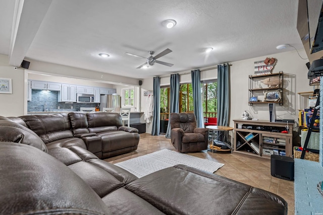 living room featuring a ceiling fan and light tile patterned floors